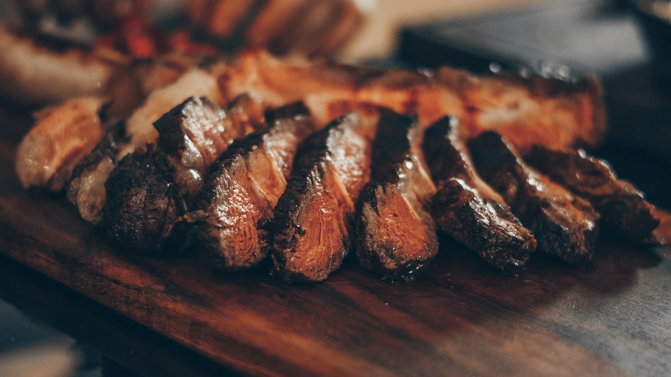 Placeholder photograph: sliced seared beef on a wooden board, standing in for a future prime rib photograph.